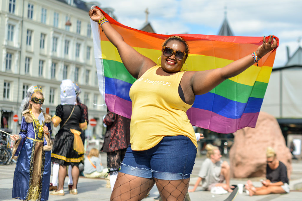 Pridedeltager holder regnbueflag højt