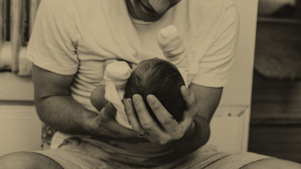 En far med sit nyfødte barn i hænderne